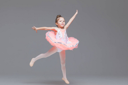 可爱可爱的芭蕾舞演员穿着粉色芭蕾舞裙练习芭蕾舞照片
