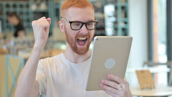 红发人在平板电脑上庆祝成功