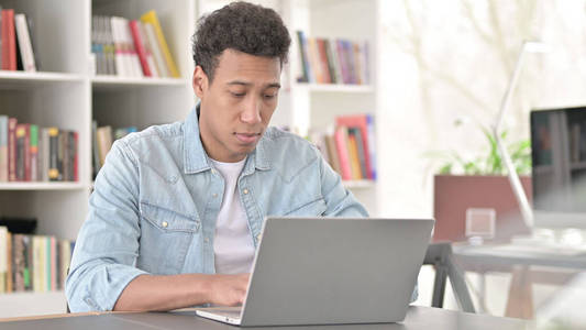 年轻的非洲裔美国人在笔记本电脑上工作