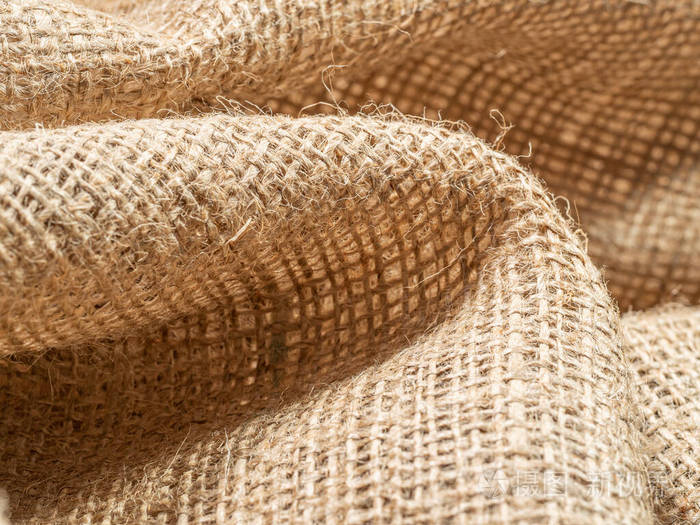 皱巴巴的粗麻布织物.棕色麻布上的特写镜头.抽象背景.棕色粗麻布的质