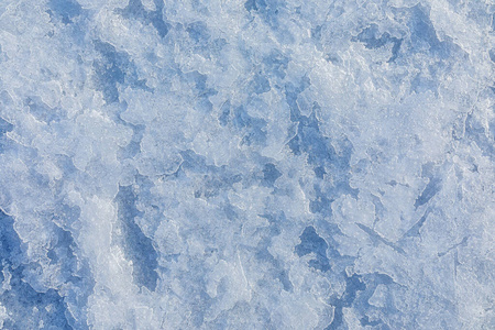 结冰的湖面上的冰的质地。蓝色背景。