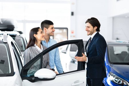情侣在豪华汽车经销店与专业经销商选购汽车