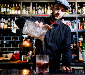 Bartender is making cocktail at bar counter. Fresh cocktails. 