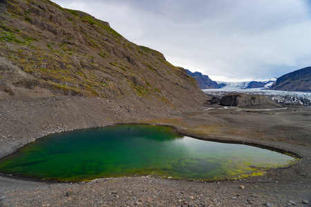 Green lake with Glacier and ash in the  with melted water and