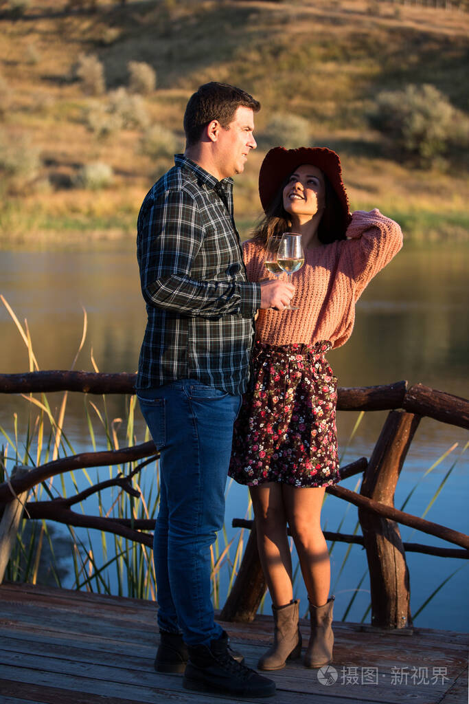 一位年轻女子在木制浮筒上仰望丈夫