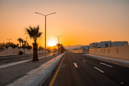 夕阳在一条有白色路标的荒芜公路上