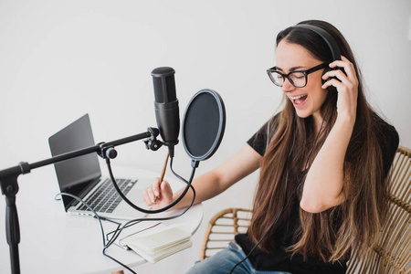 录制节目女博主在录音室录制广播播客.照片