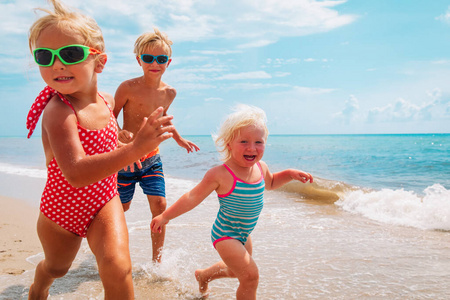 快乐的孩子们享受海滩假期，男孩和女孩们玩得很开心