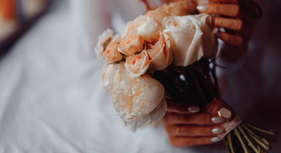 a bouquet of roses for the bride in her hands. 