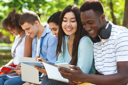 开朗交流学生交流.开朗的多种族大学朋友在户外备课照片