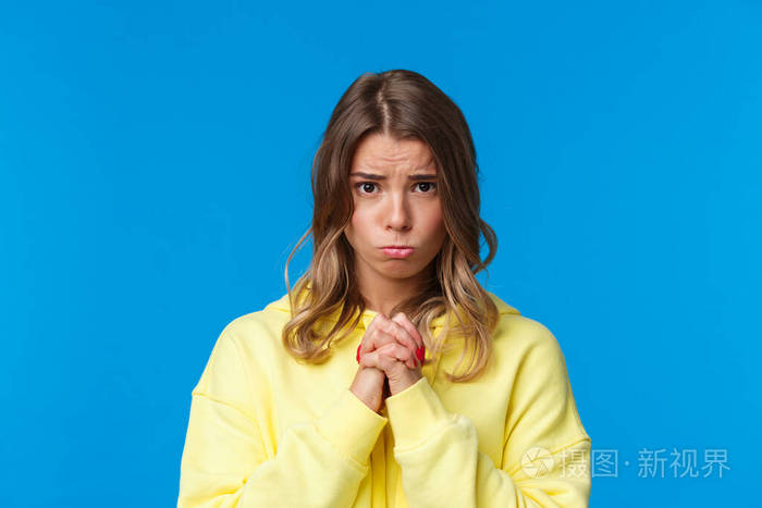 可爱又傻气的金发女孩乞求帮助的特写照片手拉手祈祷手势皱着眉头请求