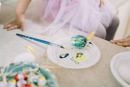 用鸡蛋画用油漆和刷子在盘子上画鸡蛋装饰照片