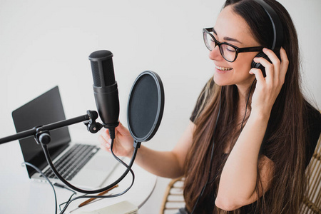 录制节目女博主在录音室录制广播播客.照片
