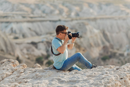 a photographer sits on rock in Cappadocia 