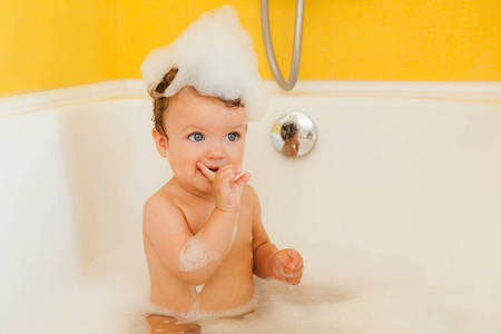 带着泡沫和肥皂泡在浴室微笑的孩子。
