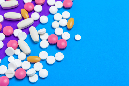 蓝色背景上的一堆五颜六色的药丸.俯视图.照片