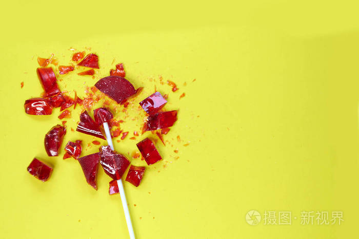破碎的心红色棒棒糖甜孤立黄色背景