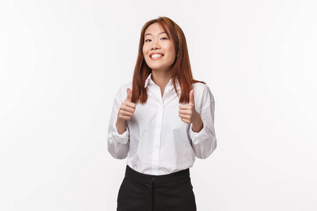 开朗鼓励的亚洲女孩为人加油,竖起大拇指微笑表示赞同,给予肯定的回答