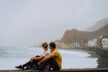 佛得角圣安陶岛。一对夫妇在海边小镇保罗前欣赏大西洋的海浪和风景
