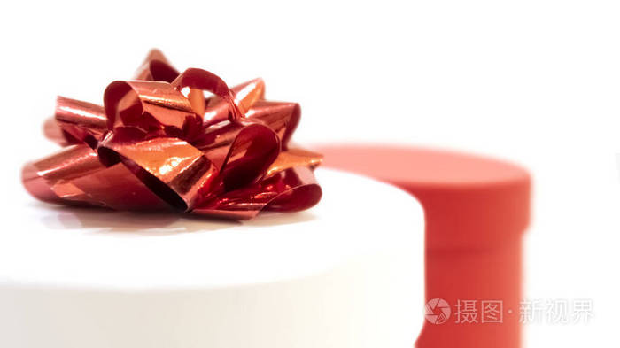 白色背景的礼品盒特写镜头。带红色蝴蝶结和红色盒子的圆柱形白色盒子。情人节，国际妇女节，生日，假日概念，模型