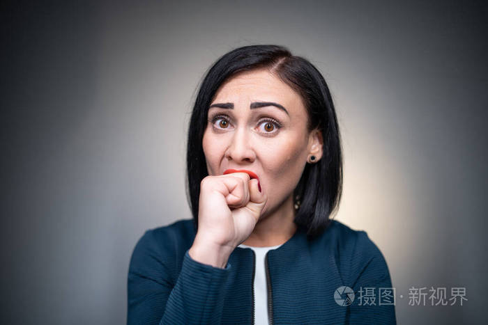 焦急的黑发女人担心和咬手指