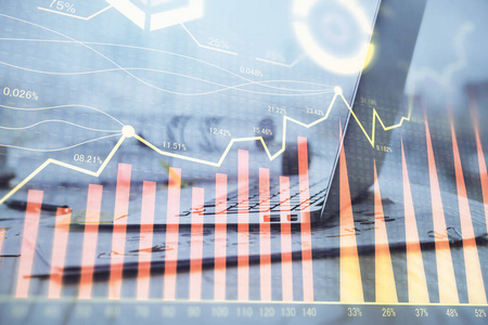 股票市场图形背景与办公桌和个人电脑.多重曝光.财务分析的概念.照片