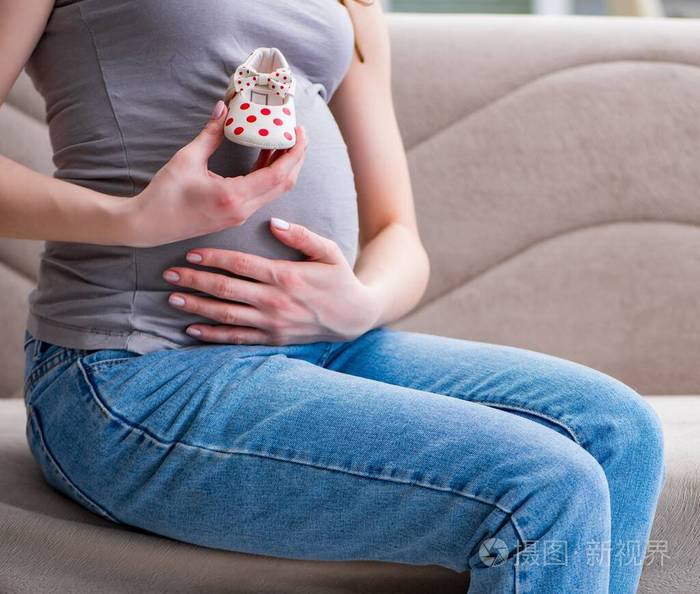 肚子大的孕妇坐在家里的沙发上