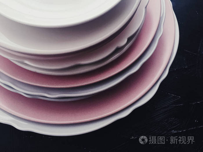 黑色背景上的一叠干净的空盘子餐具和桌子装饰