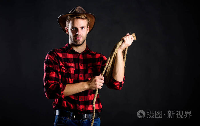 西方生活男人不刮胡子牛仔黑色背景戴帽子的人拿着绳子美国牛仔的套索