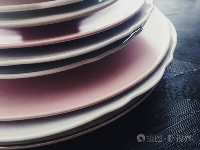 黑色背景上的一叠干净的空盘子餐具和桌子装饰