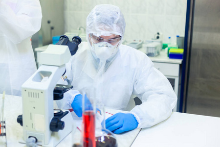 科学家们穿着防护服在一个科学实验室里研究一种危险的病毒以消除这种