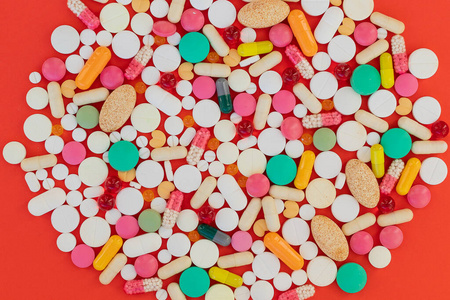 红色药丸胶囊医学背景背景。各种各样药丸，片剂。各种各样不同颜色的药片和药片。医疗保健。俯视图