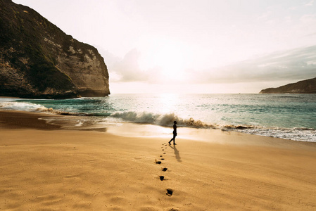 夕阳下站在山顶的人一个孤独的人站在海滩上.