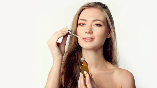 美丽的模特,在白色皮肤上涂抹精华液.水疗,护肤和健康.