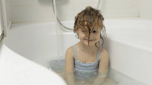 可爱的金发女孩穿着泳装洗澡.小孩洗头照片