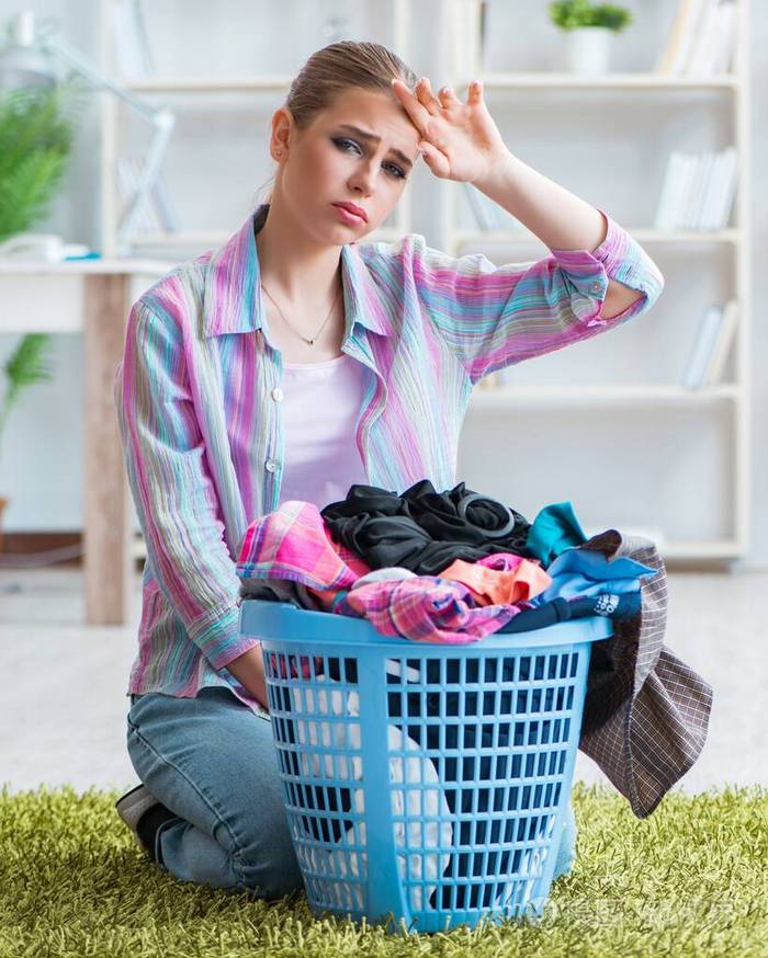 疲惫沮丧的家庭主妇在洗衣服