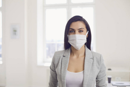 有感染冠状病毒的危险。办公室里戴着医用面具的女商人
