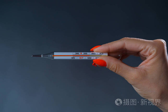 女性手拿着温度计体温很高
