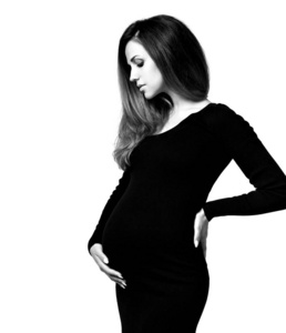 手放肚子上按摩孕妇穿着紧身衣的黑白照片.