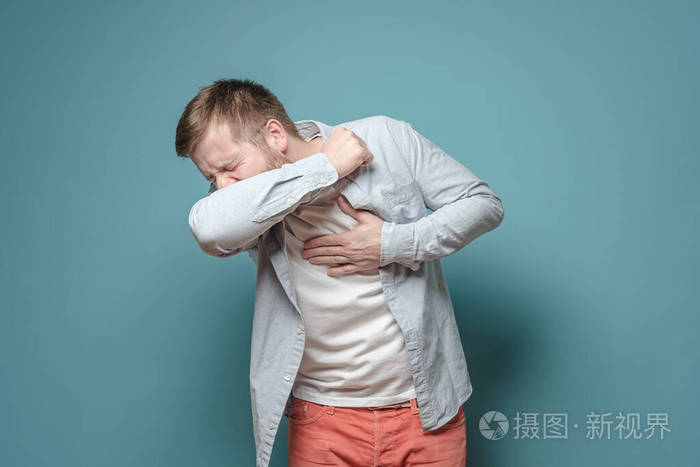 一位年轻的欧洲男子咳嗽手握胸口感到疼痛病毒传播的概念