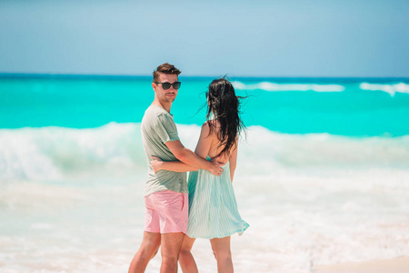 暑假期间在白沙滩上的一对年轻夫妇。