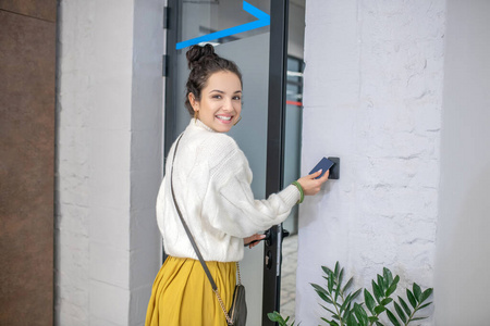 年轻女子走了,拿着门禁卡打开门,微笑着游客旅行背包