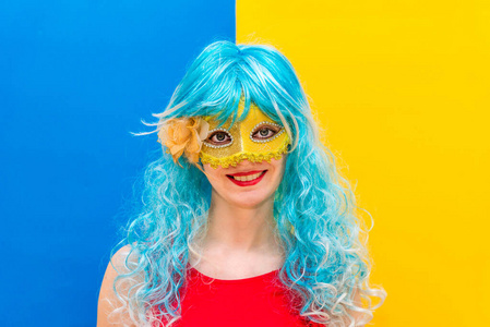 一个戴着蓝色假发和黄色面具微笑的女孩将要庆祝化装舞会.