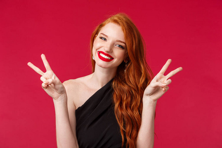 合拢的红颜色红发女人,红唇膏,展示卡哇伊和平标志,享受派对,玩得开心