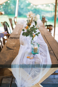 婚礼或宴会桌，装饰风格古朴，户外时尚帐篷。露天招待会，乡村婚礼