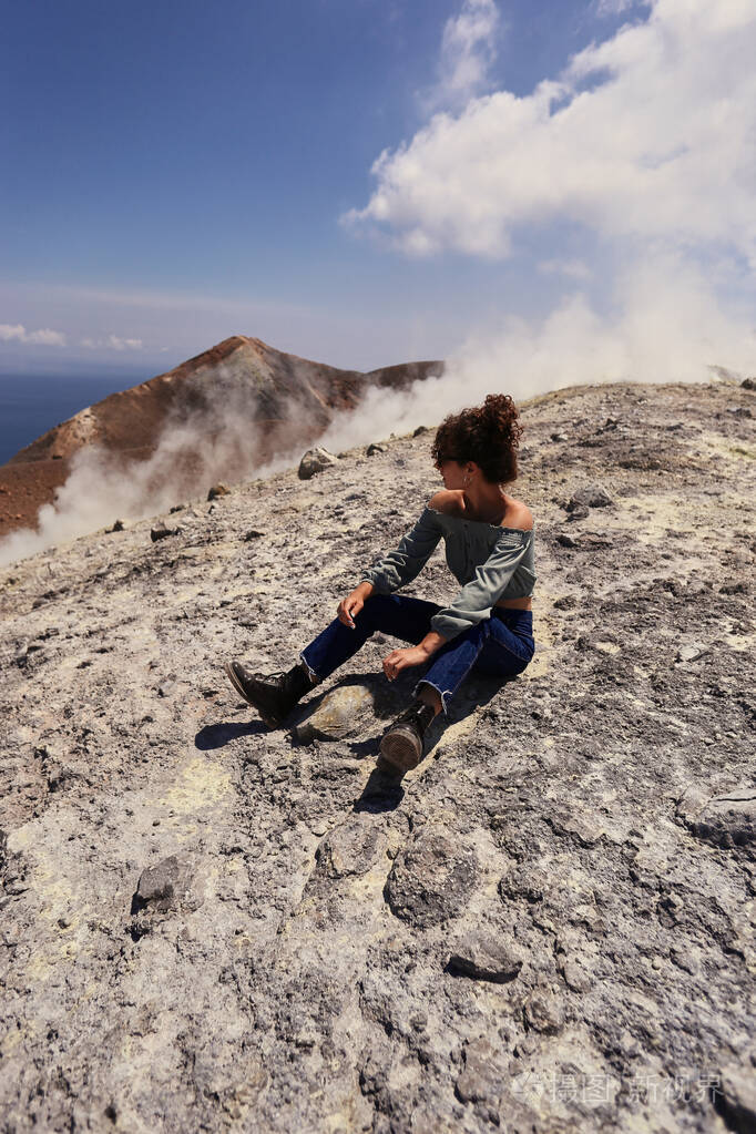 旅行女孩年轻的女博主坐在山顶上直视前方享受美妙自然的女旅行者