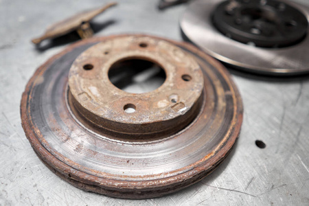 汽车修理工金属台面上的安全车制动盘和刹车片，新旧更换。汽车修理概念。