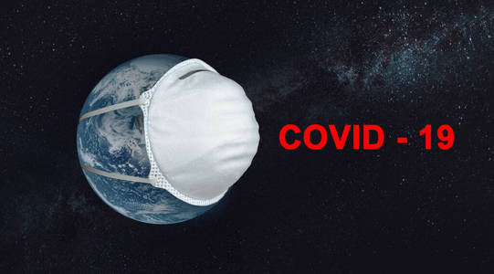 在星空的映衬下，行星地球上有一个医学面具，上面刻有covid19。概念