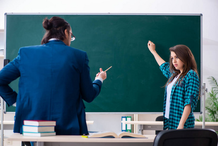 年轻帅气的老师和教室里的女学生