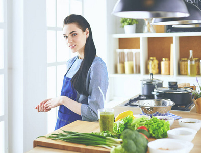 年轻女子双臂交叉站在厨房背景下的肖像